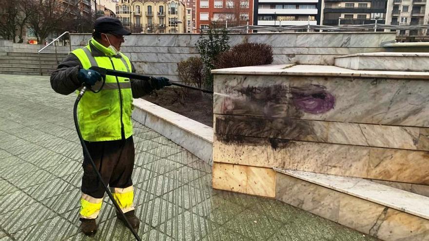 Un operario limpia una pintada en la plaza de La Marina.