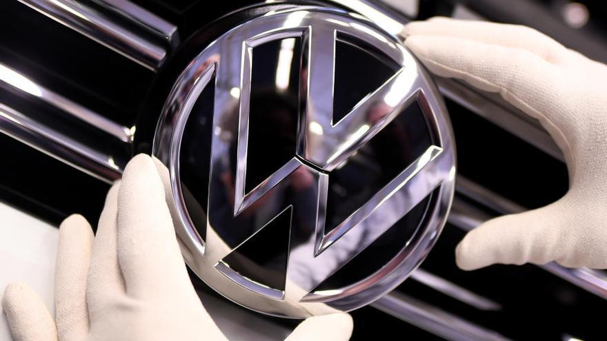 Un empleado coloca el logo de Volkswagen.