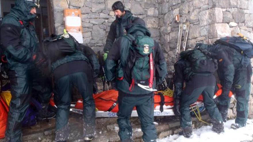 Los especialistas de la Guardia Civil de Montaña, alrededor de la camilla del montañero vasco accidentado.