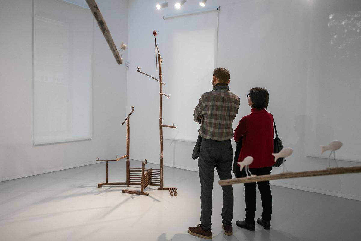 Dos personas observan las obras de la exposición de Blas Miras en la Cárcel Vieja.