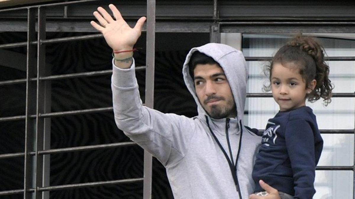 Luis Suárez saluda els aficionats uruguaians des del balcó de casa seva amb la seva filla.