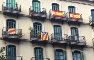 Fachada de un edificio de Barcelona con banderas española, una ’senyera’ y una ’estelada’.