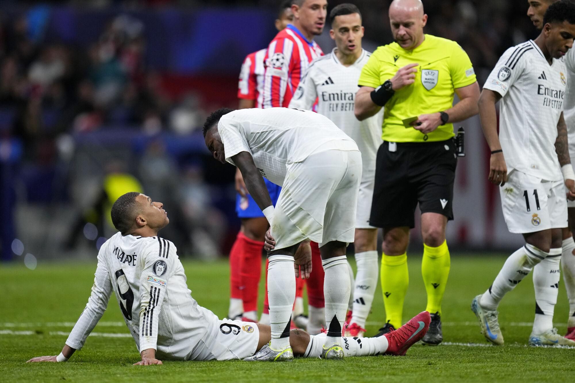 Real Madrid's Vinicius Junior speaks with teammate Kylian Mbappe, left, before taking a penalty shot during the Champions League round of 16, second leg, soccer match between Atletico Madrid and Real Madrid at the Metropolitano stadium in Madrid, Spain, Wednesday, March 12, 2025. (AP Photo/Manu Fernandez)