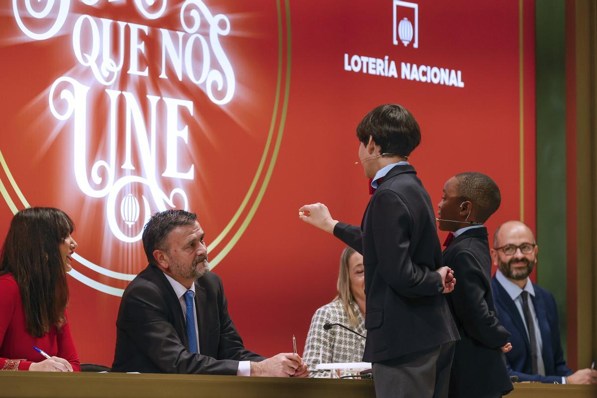 MADRID, 22/12/2022.- Los estudiantes de San Ildefonso Alonso Dávalos Durán (3d) y su compañero Ángel Abaga Elebiyo (2d) cantan el premio Gordo durante el sorteo de Navidad en el Teatro Real en Madrid, este jueves. EFE/ Javier Lizón