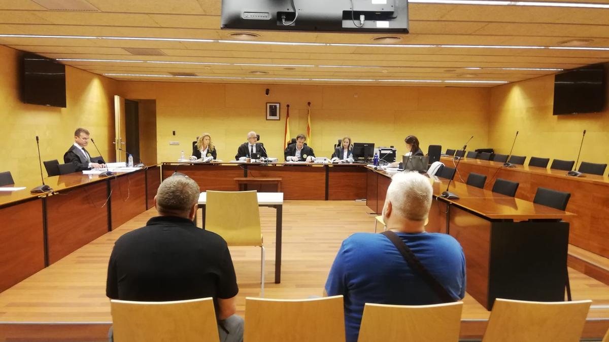 Els dos acusats d'esquenes durant el judici a l'Audiència de Girona.