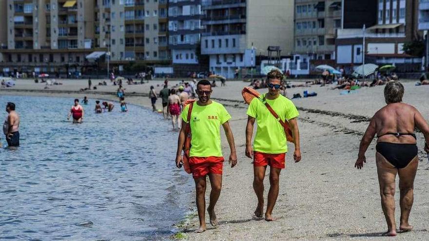 Dos socorristas paseando por la orilla de la playa Compostela, en Vilagarcía. // Iñaki Abella
