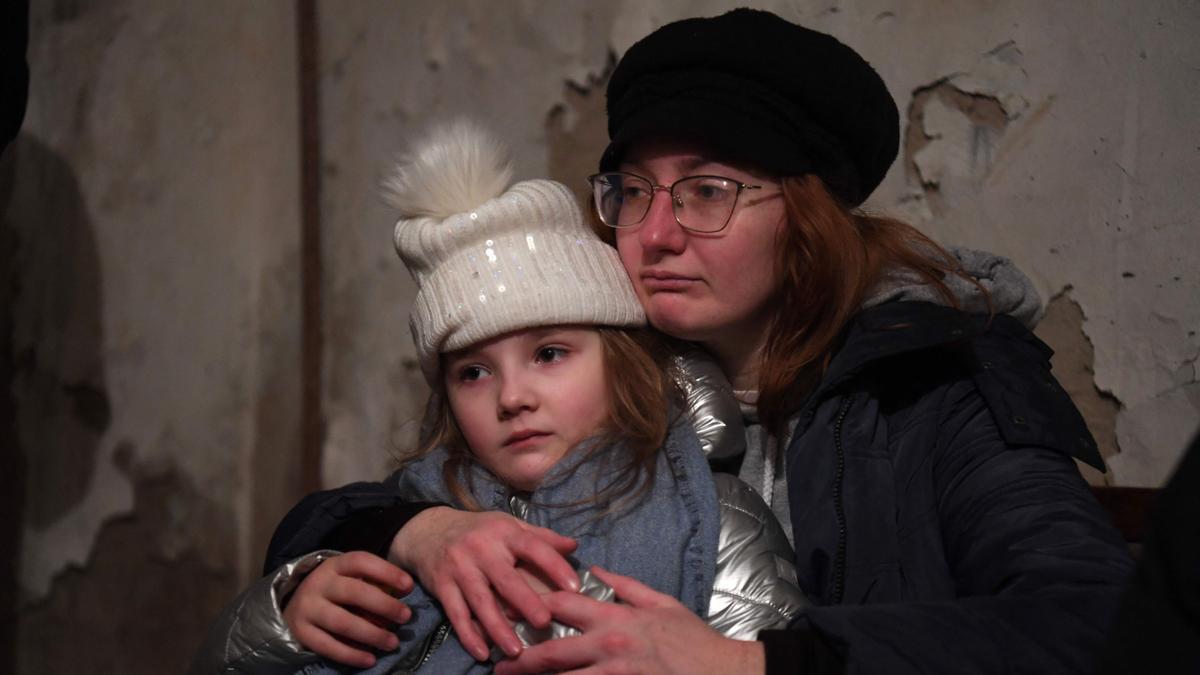 Helga Tarasova abraza a su hija Kira Shapovalova mientras esperan en un refugio subterráneo durante una alerta de bombardeo en la capital ucraniana de Kiev.