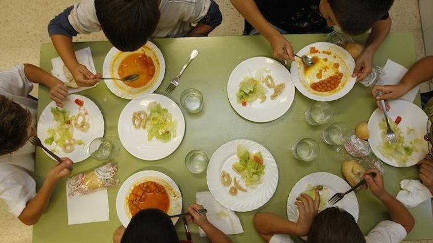 Niños almuerzan en el comedor de su colegio.