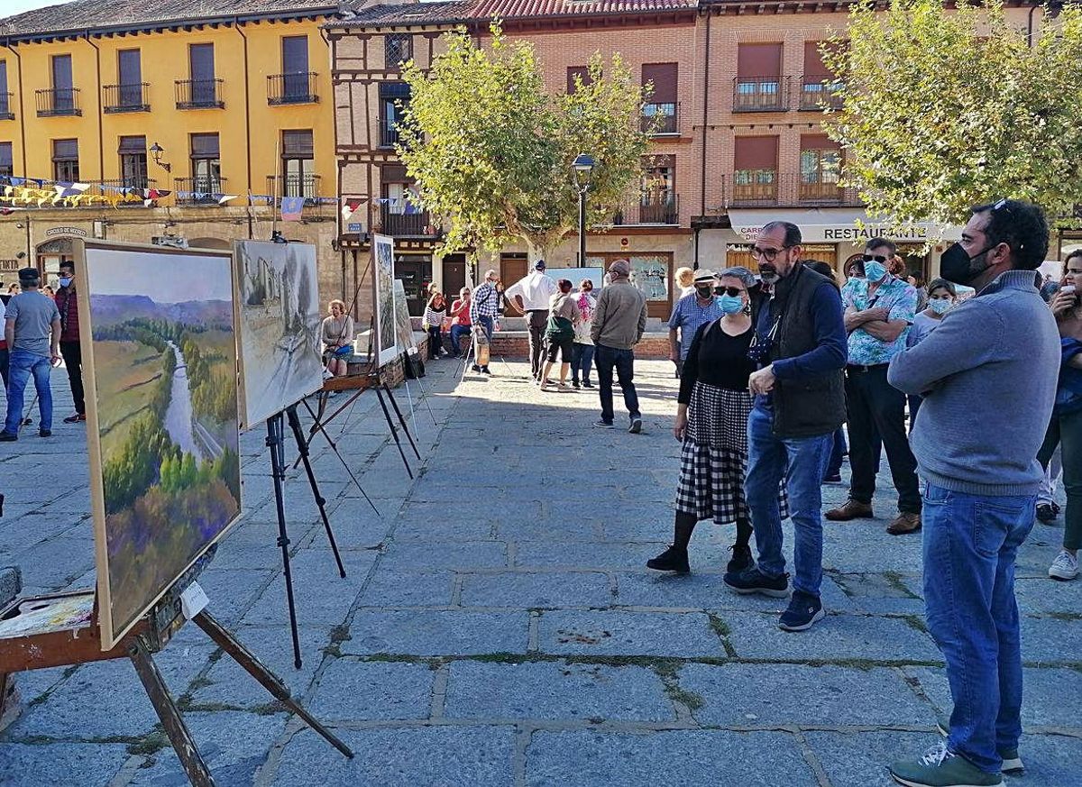 Toresanos y visitantes admiran los cuadros del certamen en La Glorieta. | M. J. C.