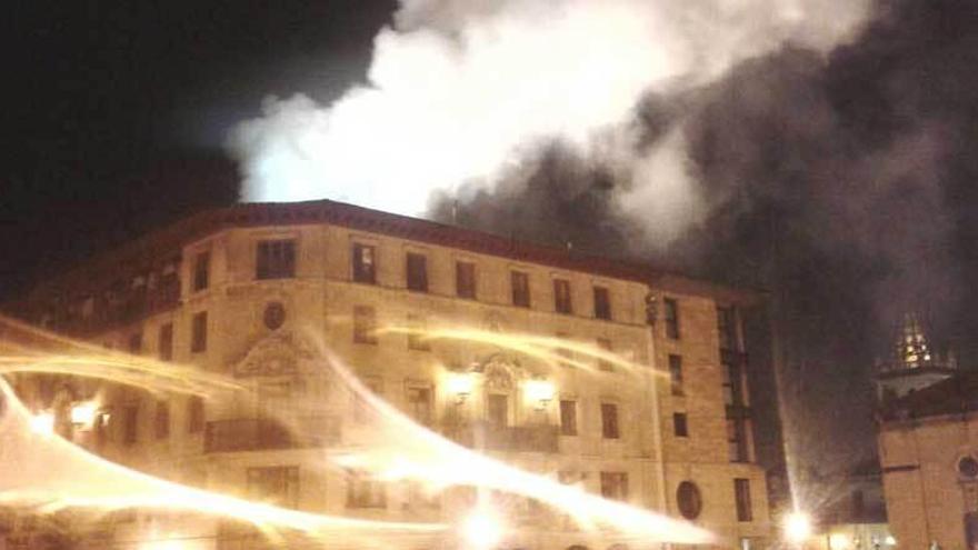 Una gran columna de humo sale del interior del edificio en llamas, en la plaza de la Catedral.