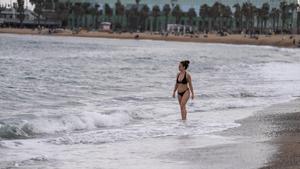Una joven pasea en bikini por la orilla de una playa de Barcelona, el 23 de marzo pasado.