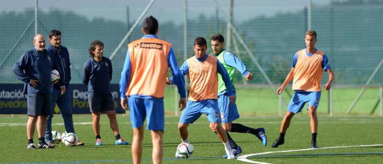 Kevin Presa, con el balón, durante un entrenamiento ante la mirada de Pepe Rico, Roberto Feáns y Luisito. // Gustavo Santos