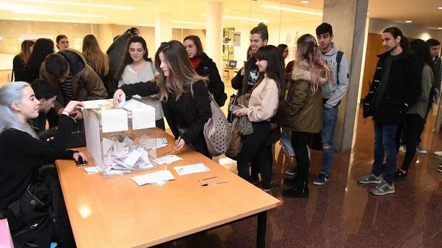 Universitarios votan por la monarquía o la república en la urna de una facultad del campus coruñés.