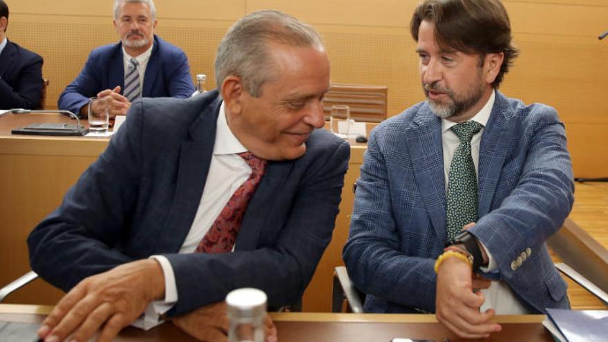 El presidente saliente del Cabildo de Tenerife, Carlos Alonso (d), de CoalicióN Canaria, bromea con el que fuera su vicepresidente Efraín Medina