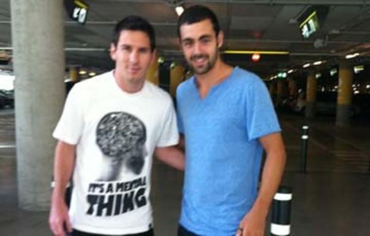Messi posa amb un aficionat blaugrana a l’aeroport del Prat, aquest dimecres.