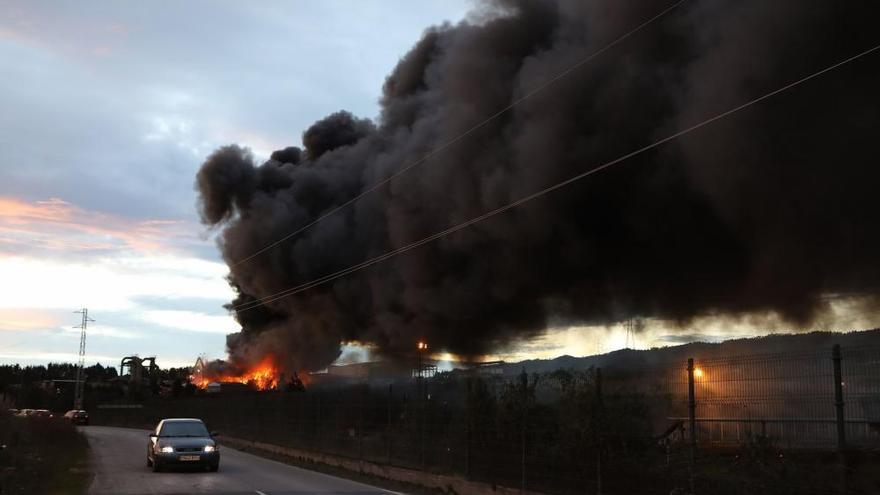 Labores de extinción del incendio de un desguace en Gijón