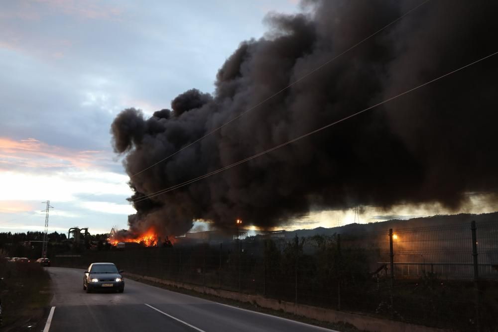 Labores de extinción del incendio de un desguace en Gijón