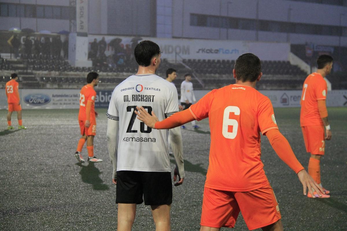 Jugadores del Ontinyent 1931 y del Atzeneta en el partido en el Clariano, protagonizado por la lluvia.