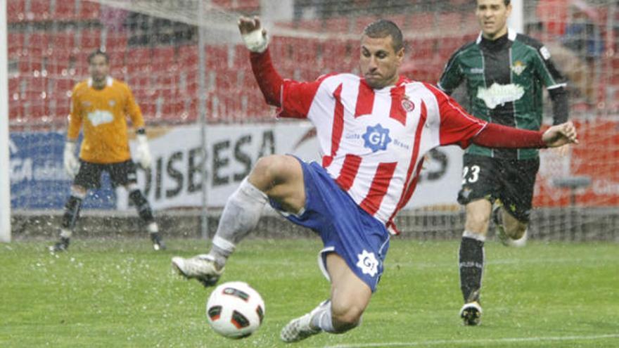 el partit en imatges José Martínez llisca sobre la gespa de Montilivi davant l&#039;atenta mirada de Nacho, jugador del Betis.president i exjugador del Betis Rafa Gordillo.