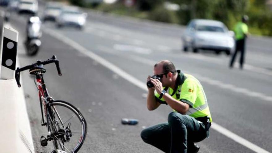 Un guardia civil, sacando fotos de la bici de la víctima, donde se observa cómo quedó la rueda trasera.