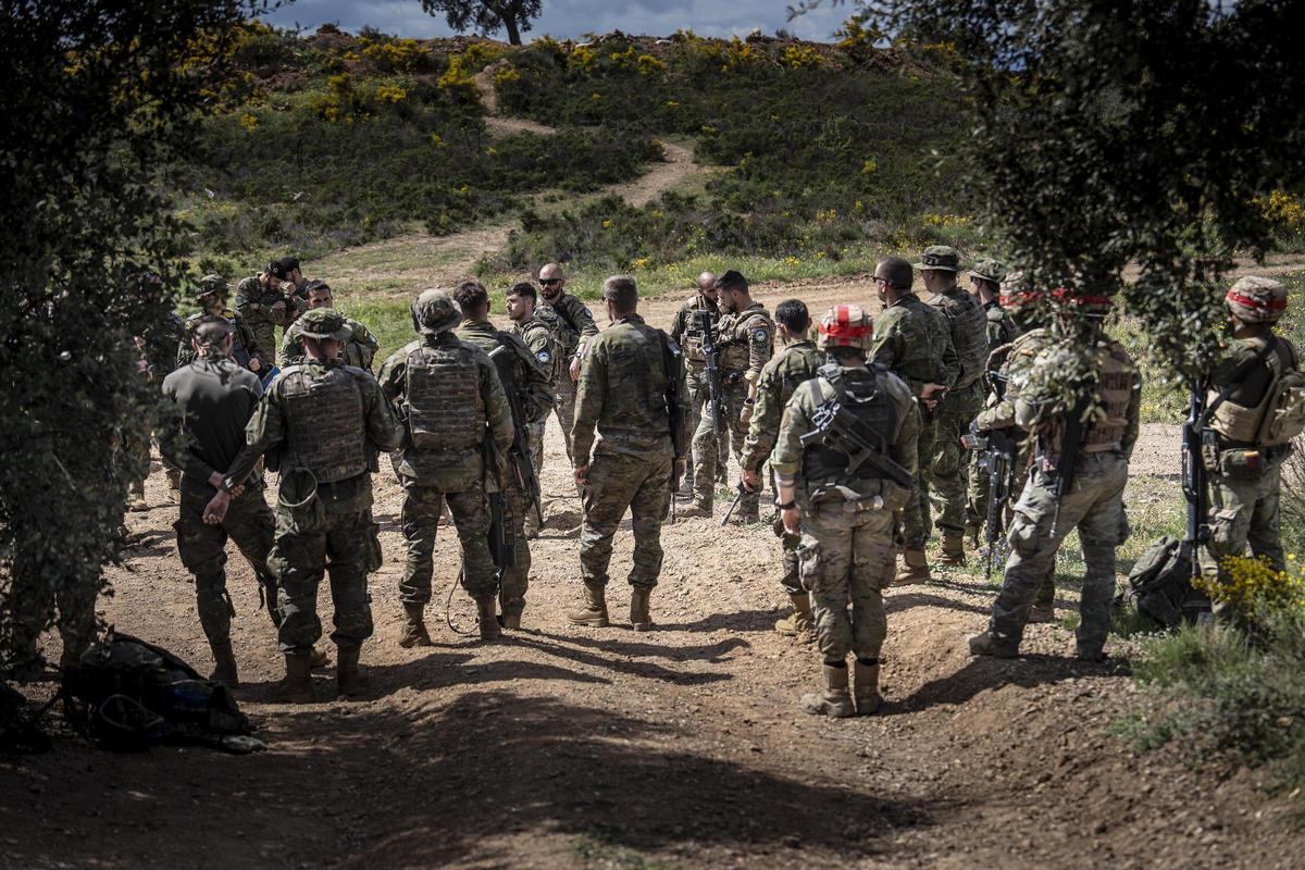 El 'juicio crítico: cuando acaba la simulación del combate, barbudos rubios y sonrosados, jadeando aún, se despojan del casco sacando al sol su pelo mojado por el sudor, se sueltan el chaleco antifragmentos, bajan el hocico del fusil HK, que alguno acaricia distraídamente como a un cachorro.