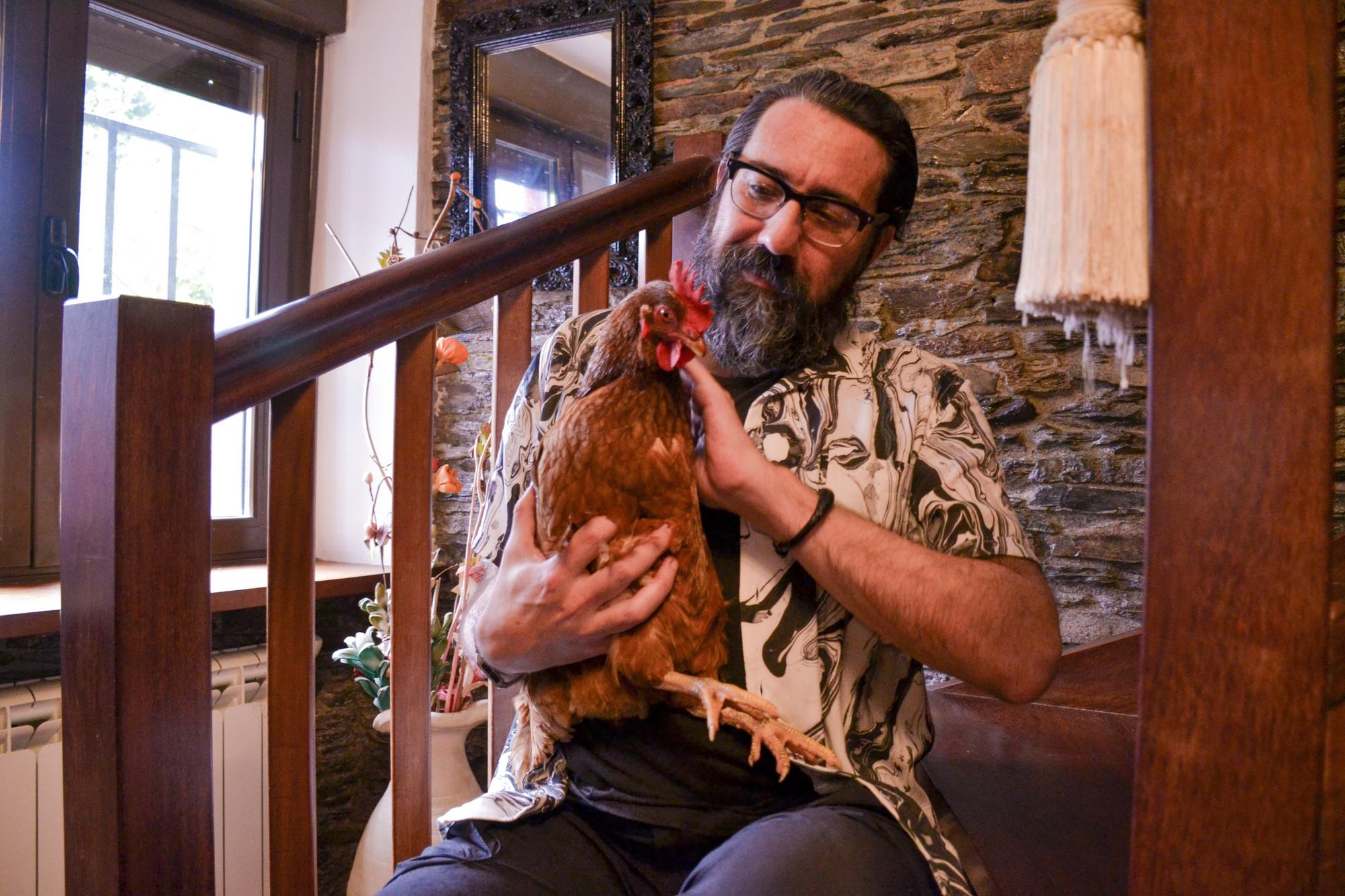 Luis Robledo posa en el interior de su casa con algunas de las gallinas que tienen en Villacondide.