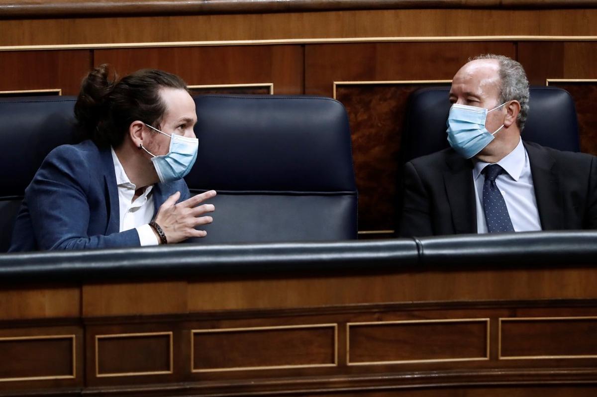 GRAF4765. MADRID, 21/10/2020.- El vicepresidente segundo, Pablo Iglesias (i), conversa con el ministro de Justicia,Juan Carlos Campo, durante la moción de censura de Vox al gobierno de coalición en el Congreso de los Diputados este miércoles. EFE/Mariscal