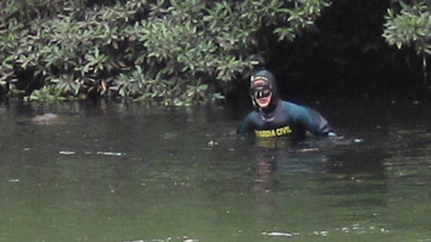 Uno de los buzos del GEAS en el lugar donde se localizó el cuerpo y antes de sacarlo del río, ayer sobre las 13,00 horas.  // D.P.