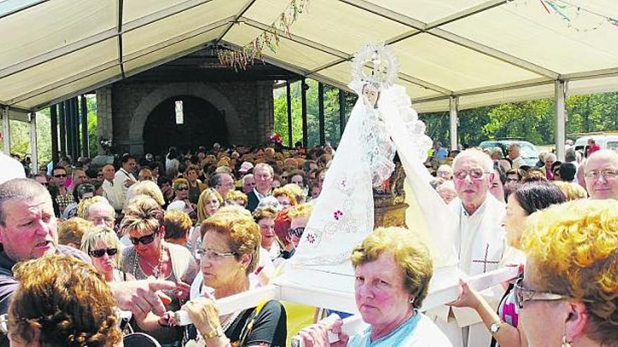 La imagen de la Virgen de la Cabeza sale del santuario, en procesión, arropada por cientos de fieles.