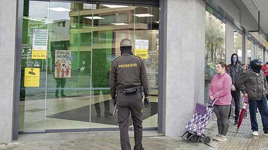 Un vigilante controla el acceso a un supermercado, ayer en Palma.
