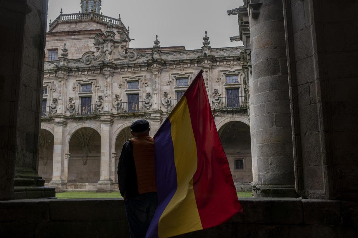 Un hombre porta la bandera de la República en el deambulatorio del claustro del monasterio de Celanova, donde se celebró este domingo el acto de homenaje a las víctimas del franquismo.