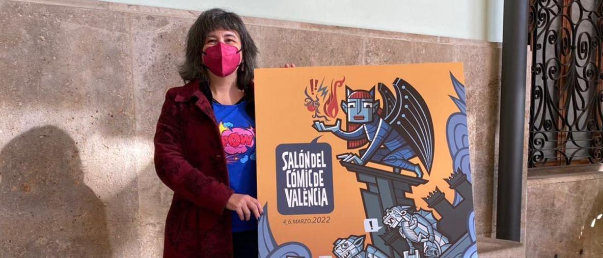 La ilustradora Cristina Durán junto al cartel del Salón del Cómic, presentado ayer en La Nau. | LEVANTE-EMV