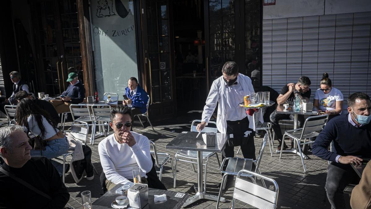 Un camarero atiende las mesas de una terraza de Barcelona.