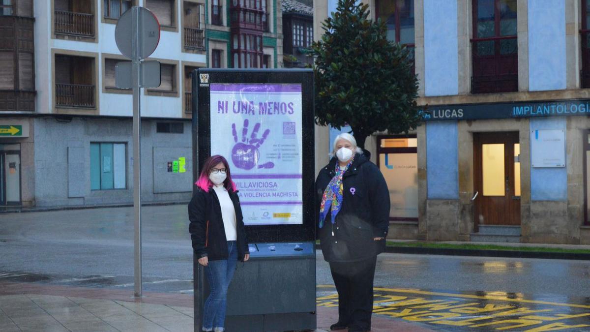 Rocío Campos, a la derecha, con Cristina Simón, junto a uno de los carteles de la campaña, en Villaviciosa. | O. P.