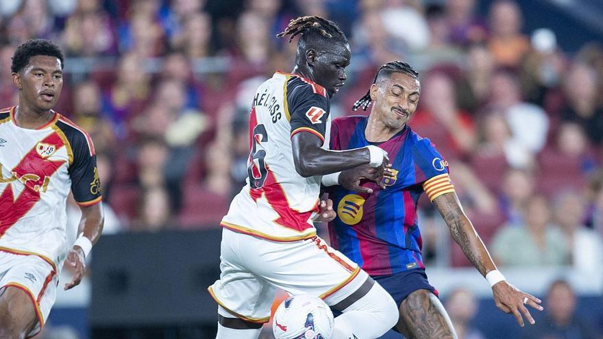 Raphinha topa amb Pathe Ciss en el partit d’ahir al Camp Nou.  | JORDI COTRINA