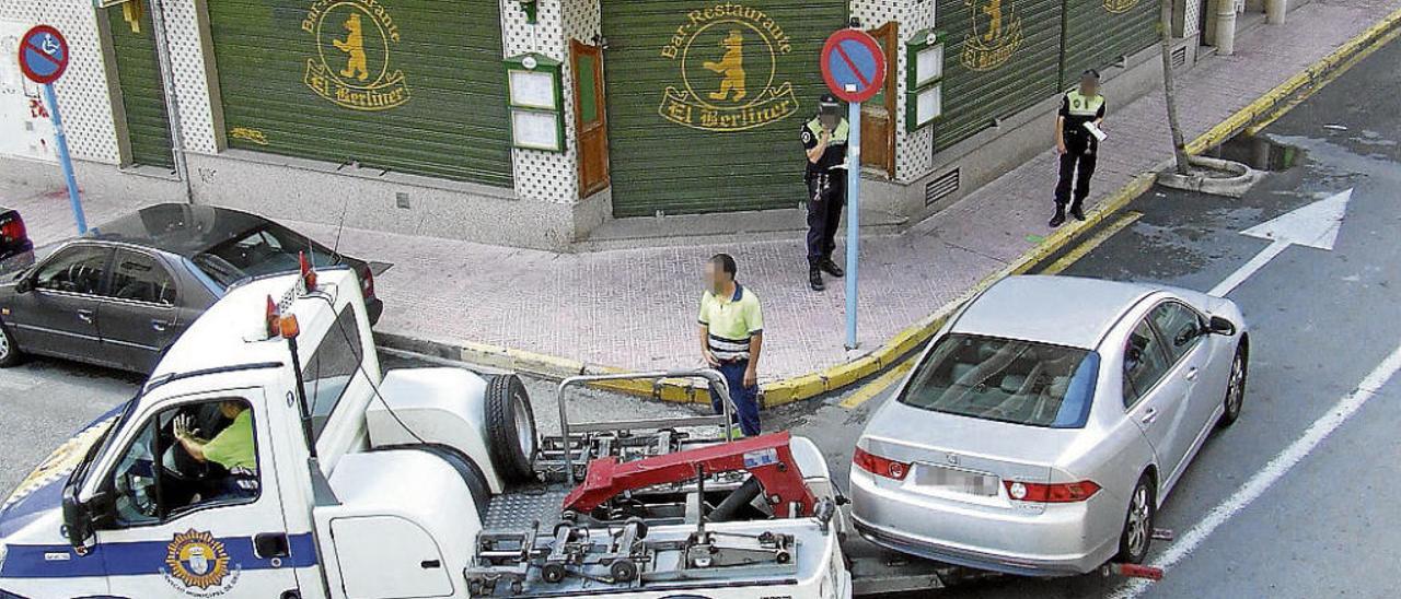 La grúa arrastra un vehículo sancionado por la Policía Local en el centro de Torrevieja.