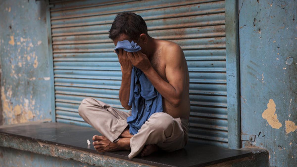 Un hombre se limpia el sudor de la cara para hacer frente a la ola de calor en Nueva Delhi, India.