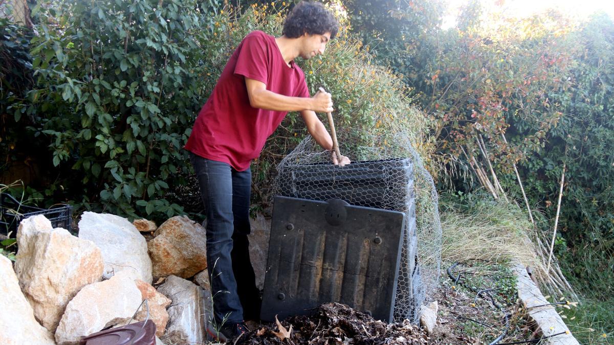 El veí de Girona Marcel Llavero remenant el compostador que té a casa seva al barri de Montjuïc de Girona