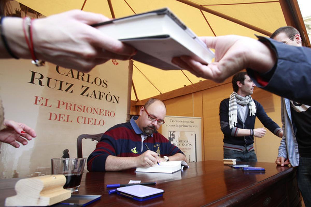 Carlos Ruiz Zafón firmando libros en el paseo de Gràcia.
