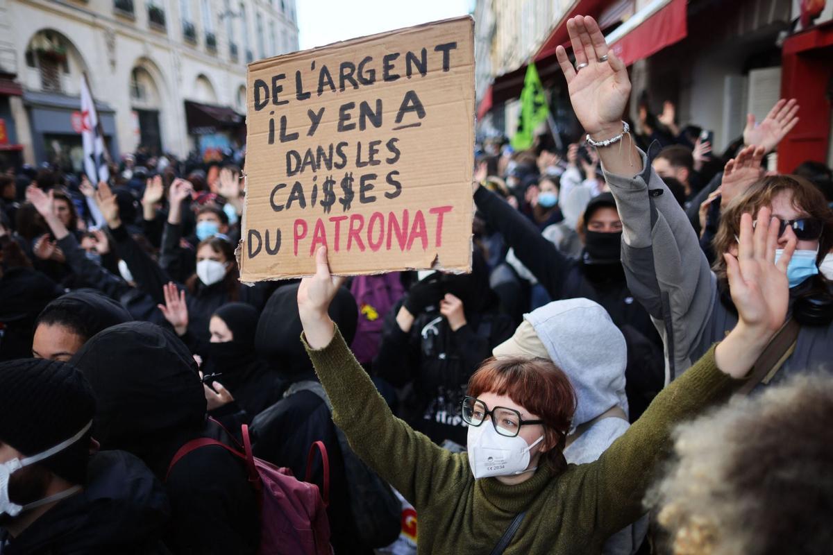 Una manifestante muestra un cartel en el que se puede leer "Hay dinero en las cajas de los patronos', durante una protesta este sábado en París.
