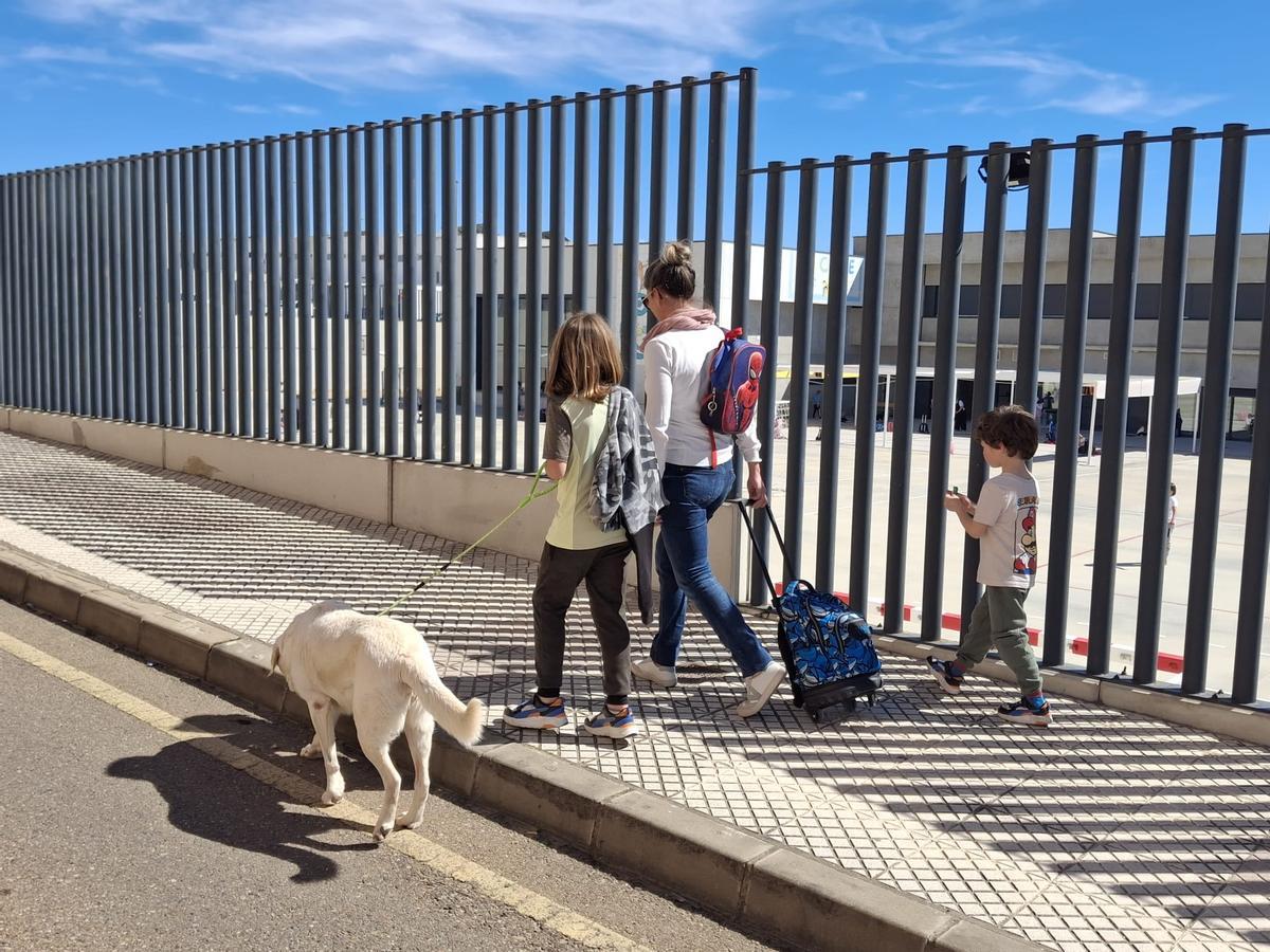 Una madre acompaña a sus dos hijos de regreso a casa tras la jornada escolar en el colegio de Cerro Gordo.