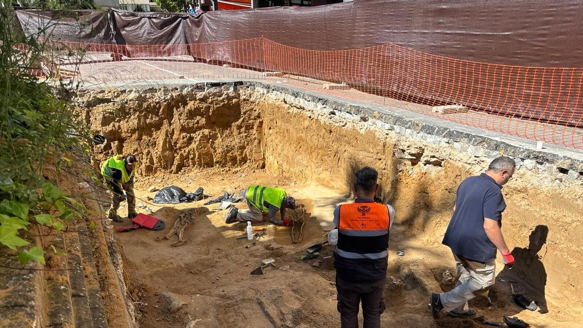 Varios peones y un arqueólogo durante los trabajos de exhumación de cuerpos en el yacimiento de la avenida de Huelva de Badajoz.