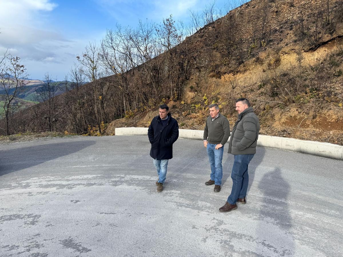 José Luis Fontaniella, a la izquierda, y Ángel Menéndez, a la derecha, en una curva de la carretera con un miembro de la empresa encargada de obra.
