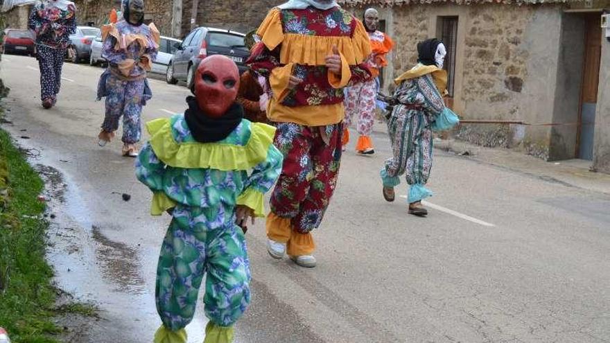 Los enmascarados corren por una de las calles del pueblo.