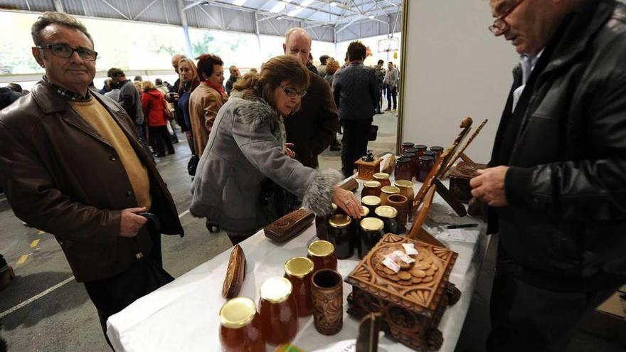 Asistentes a la Feria de la miel, ayer, en uno de los doce puestos de la muestra.