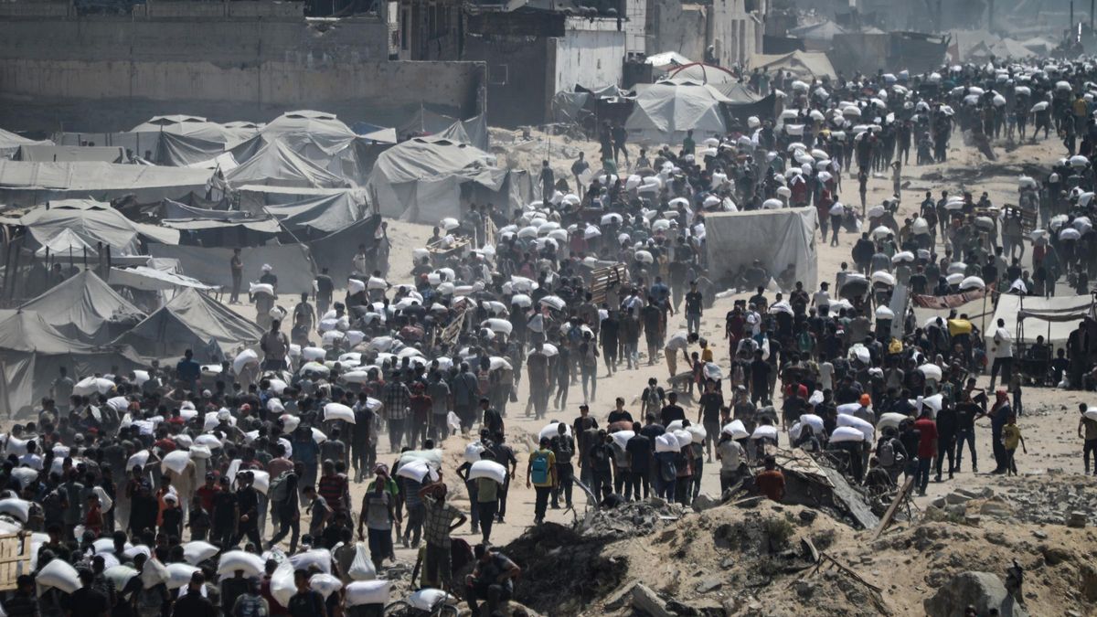Palestinos cargados con harina tras la llegada de un convoy humanitario en ciudad de Gaza