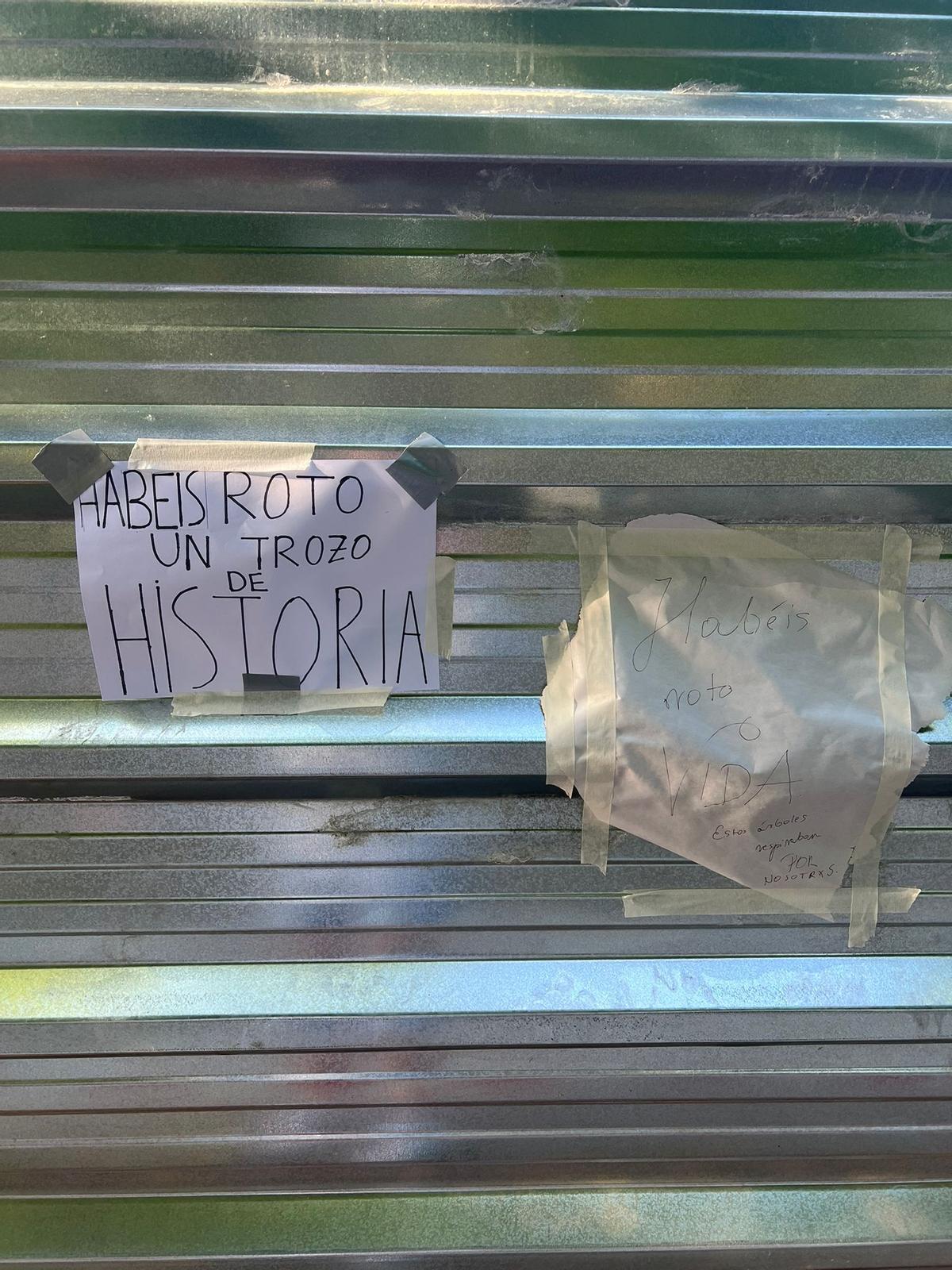 Carteles pegados por los vecinos en la valla metálica que cierra la parcela