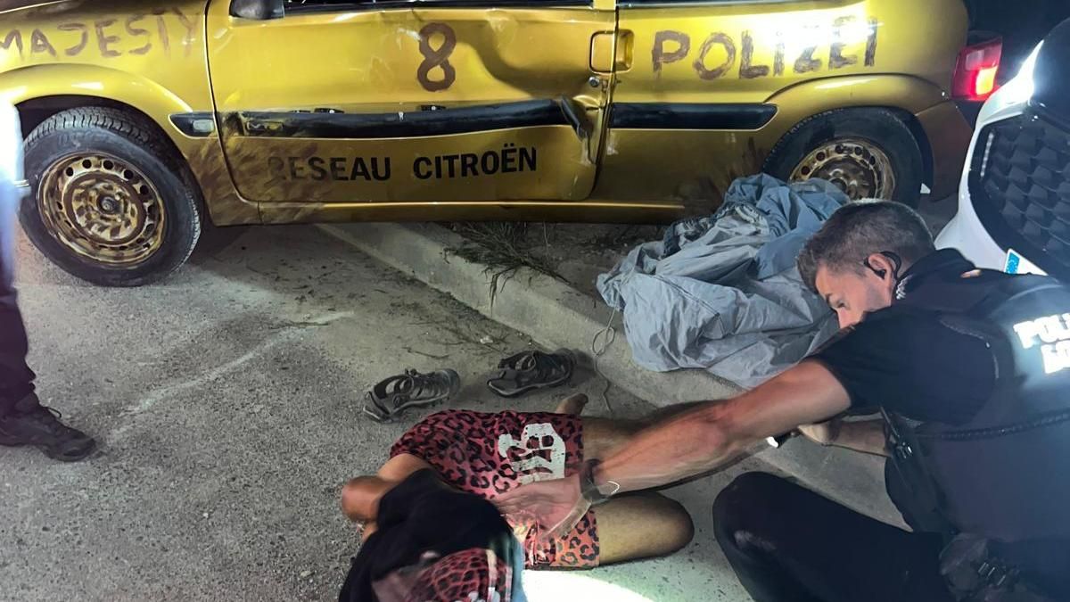 El arrestado, en el suelo, delante del coche que conducía