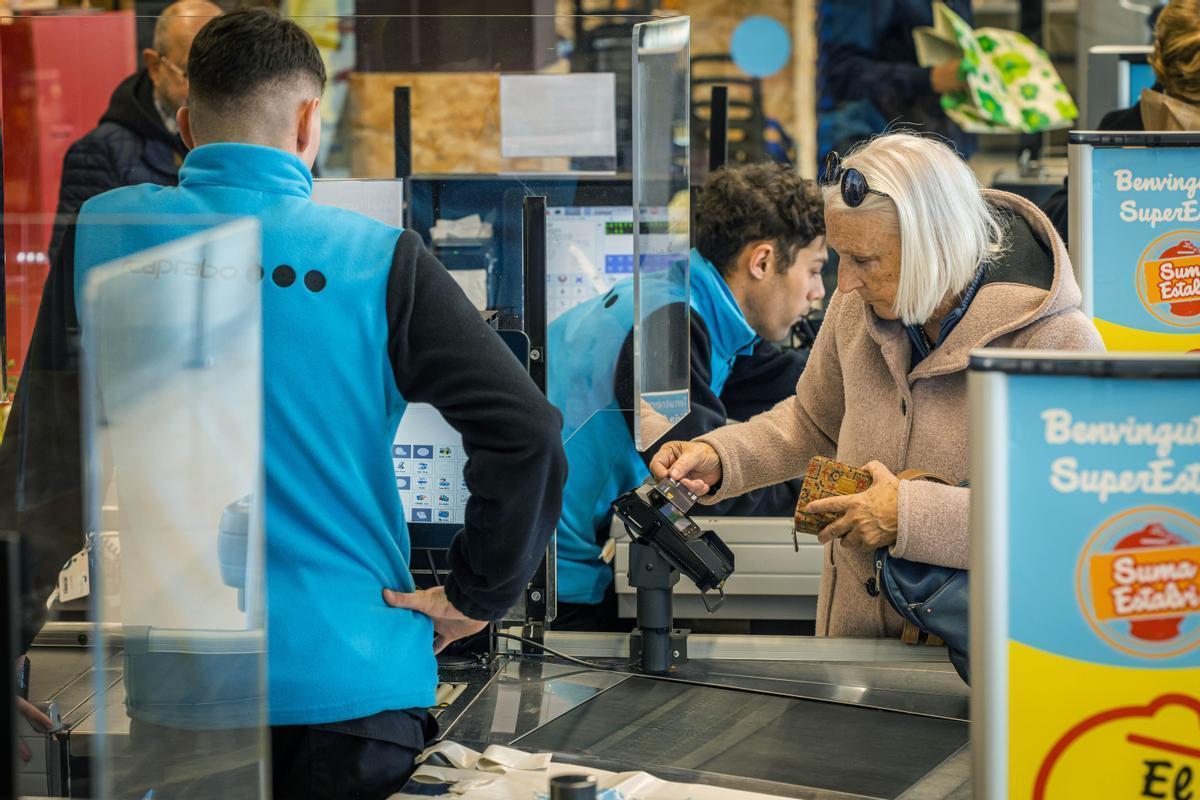 Una mujer compra en un supermercado Caprabo, marca propiedad del grupo Eroski.
