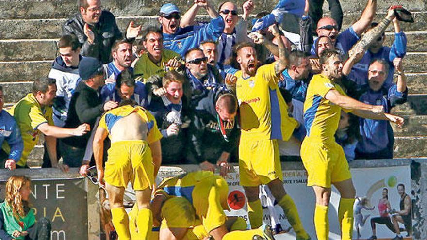 Los jugadores del Atlético Baleares se abrazan con los aficionados blanquiazules después de la consecución del gol de Isma en el instante final del partido.